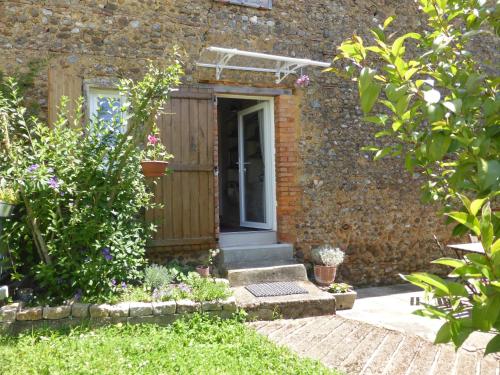 an entrance to a brick house with a wooden door at Chambre d'hôte Les Papillons - Chez Gilles et Myriam in Samadet