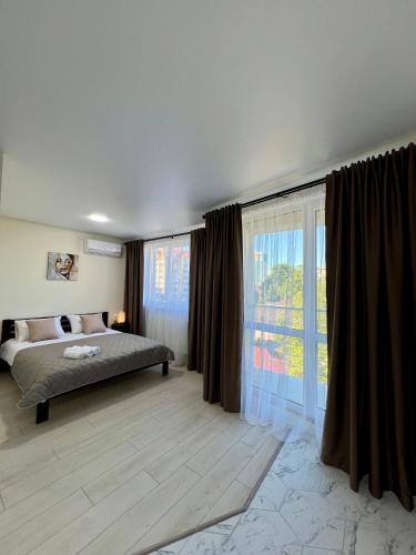 a bedroom with a bed and a large window at apartments in Ternopil city in Ternopilʼ