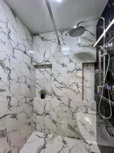 a bathroom with marble walls and a shower at apartments in Ternopil city in Ternopilʼ