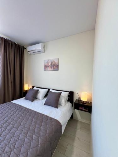 a bedroom with a large bed and two lamps at apartments in Ternopil city in Ternopilʼ