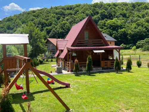 a log house with a slide and a playground at Vikendica Bosnjak in Sarajevo