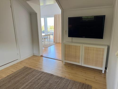ein Wohnzimmer mit einem Flachbildfernseher an der Wand in der Unterkunft Kustidyll med havsutsikt in Hyppeln