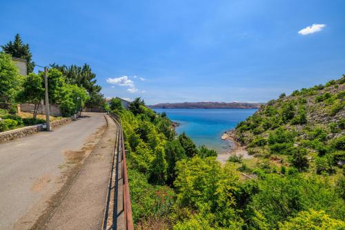 een spoorlijn naast een weg naast een watermassa bij Apartment Ivan in Ribarica