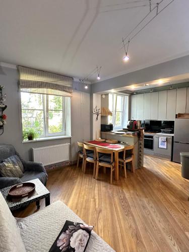 a living room with a table and a kitchen at Andrea Apartamenti in Jūrmala