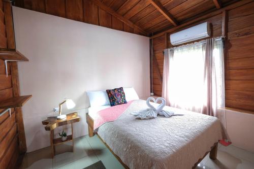a small bedroom with a bed and a window at Cabaña ITZE in Fortuna
