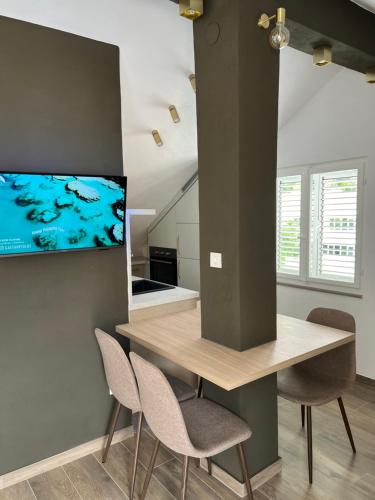 a kitchen with a table and chairs and a tv at Choco's Seaside Studio Apartment in Korčula
