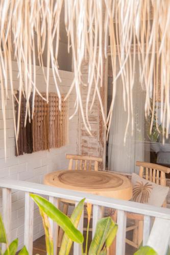 two tables and chairs in a room with plants at Les Vagues - Hotel Villa & Beach Club - Gili Air in Gili Air