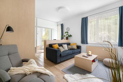a living room with a couch and a table at Apartment in a quiet part of Brno - Kohoutovice in Jundrov