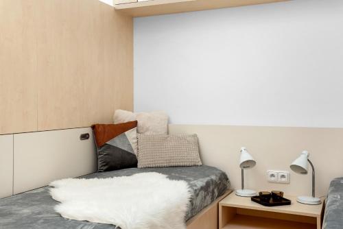 a bedroom with a bed and a table with lamps at Apartment in a quiet part of Brno - Kohoutovice in Jundrov