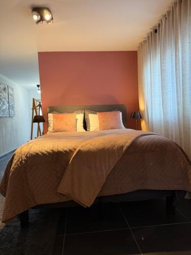 a bedroom with a bed with a red wall at Sweet Dreams in Middelburg