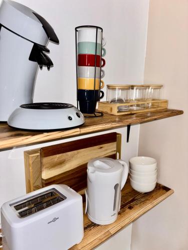 une étagère de cuisine avec un mixeur et d'autres articles de cuisine dans l'établissement Appartement au cœur de Collias, à Collias