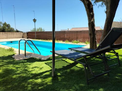 a hammock in a yard next to a swimming pool at Casa Flor de Taronger in Viladecáns