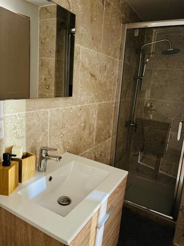 une salle de bain avec un lavabo et une douche dans l'établissement Appartement au cœur de Collias, à Collias