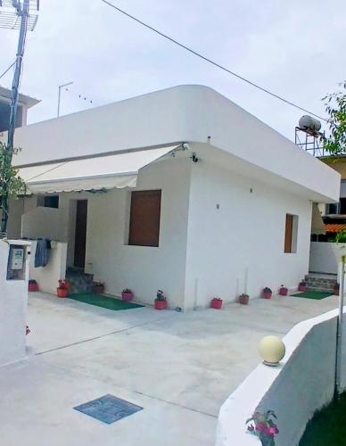 a white building with a white roof at Rentrooms Geni in Ksamil