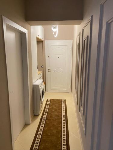 a hallway with a white door and a microwave at Saranda Apartment in Polisi i Vogël