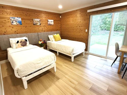 a bedroom with two beds and a window at Vancouver Lake City Way Guesthouse 10 min to SkyTrain in Burnaby