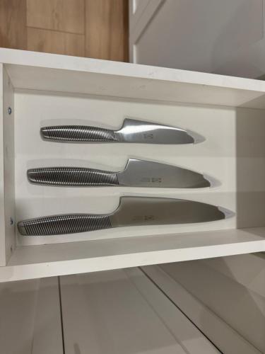 three knives in a white drawer in a kitchen at Vancouver Lake City Way Guesthouse 10 min to SkyTrain in Burnaby