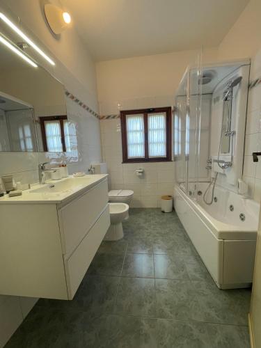 a bathroom with two sinks and a tub and a toilet at Villa Gianna affitta camere in Inverigo