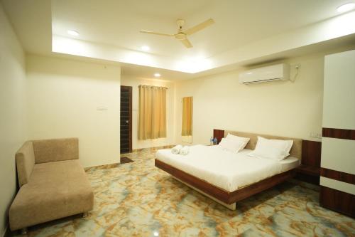 un dormitorio con una cama y una silla en Bhandari Palace, en Vidisha