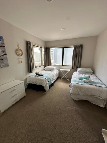 a bedroom with two beds and a window at Grace Getaway - Beach, Cafes & The Mount at your doorstep in Mount Maunganui