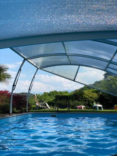 une piscine avec un auvent au-dessus d'une piscine dans l'établissement Séjour sur les coteaux, à Jurançon