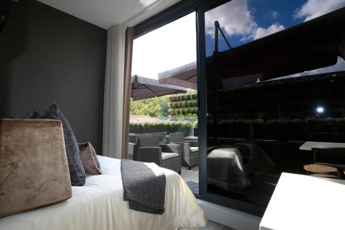 a bedroom with a bed and a large glass window at Charm Flats in Lisbon