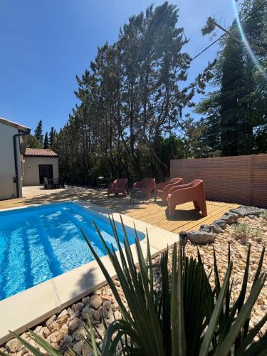 - une piscine dans une cour avec des chaises et une terrasse dans l'établissement La vill'ona, à Grospierres