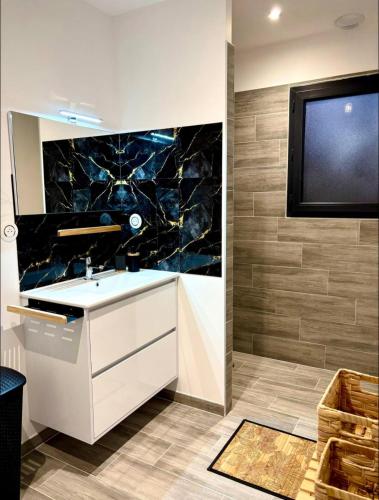 La salle de bains est pourvue d'un lavabo et d'une télévision murale. dans l'établissement La vill'ona, à Grospierres