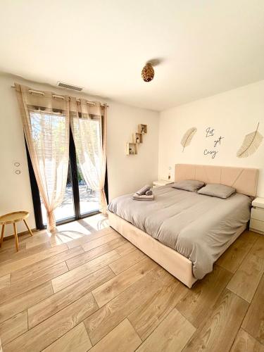 une chambre avec un lit et un parquet dans l'établissement La vill'ona, à Grospierres