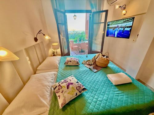 a small room with a bed with a green table at TRAVELLERS BEAUTIFUL ELEN Agios Gordios Sea in Agios Gordios