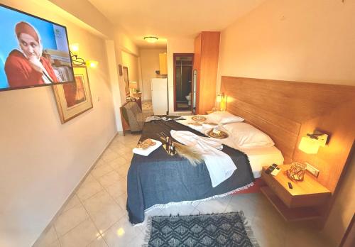 a hotel room with a large bed and a television at TRAVELLERS BEAUTIFUL ELEN Agios Gordios Sea in Agios Gordios