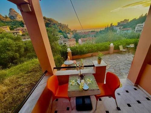 a balcony with a table and chairs and a view of a city at TRAVELLERS BEAUTIFUL ELEN Agios Gordios Sea in Agios Gordios