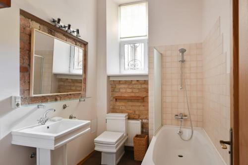 a bathroom with a sink and a tub and a toilet at Spacious 82 m2 2 bedroom Flat and Roof Terrace in the Heart of Riga in Rīga
