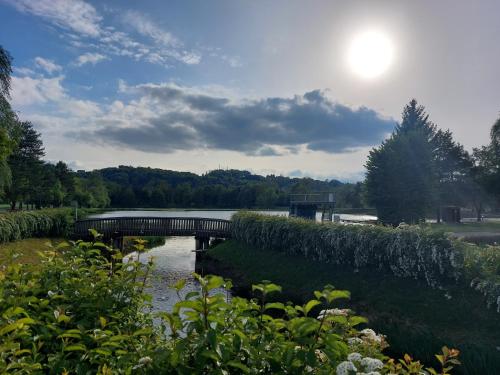 a bridge over a river with the sun in the sky at SeeRuhe - Mobilheim Grosssteinbach in Grosssteinbach