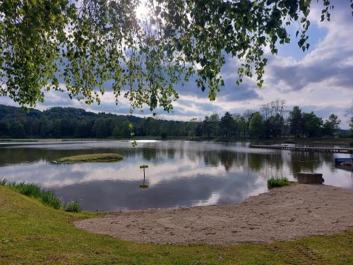a lake with a sign in the middle of it at SeeRuhe - Mobilheim Grosssteinbach in Grosssteinbach