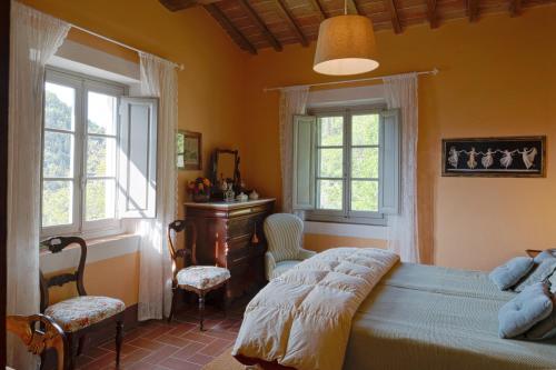 1 Schlafzimmer mit einem Bett, 2 Fenstern und einem Schreibtisch in der Unterkunft Agriturismo Il Ponticello in Vaiano