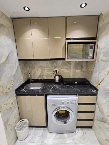 a kitchen with a washing machine and a sink at porto marina 3 in El Alamein
