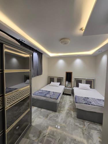 a bedroom with two beds and a walk in closet at porto marina 3 in El Alamein