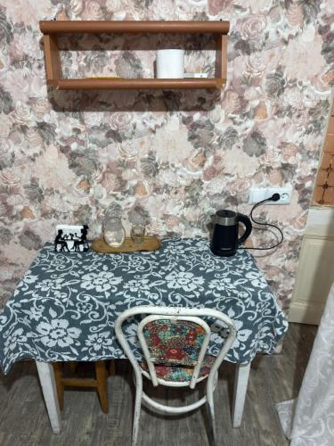 a table with a chair and a table with a tablecloth at Guest House Nise in Tbilisi City
