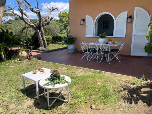 een tafel en stoelen in de tuin van een huis bij Un Paradiso a Sorrento con piscina in Massa Lubrense