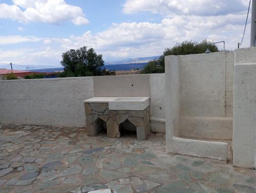 a stone bench sitting next to a wall at Kyriaki's Studio Aigina in Souvala
