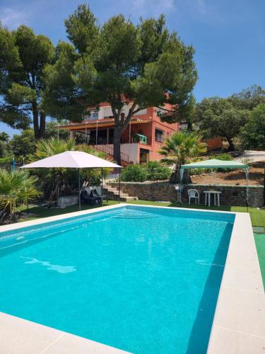 ein großer blauer Swimmingpool neben einem Gebäude in der Unterkunft Casa Terra in Hontanar