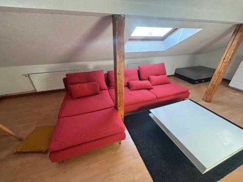 a living room with a red couch and a window at Work'n'Sleep Mulhouse in Mulhouse