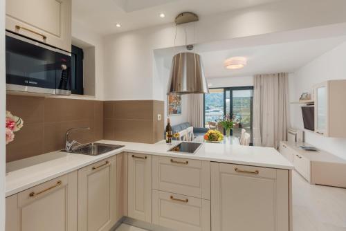 科托尔Apartments Los Olivos的厨房配有白色橱柜和水槽