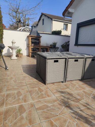 un patio avec un barbecue et une cheminée dans l'établissement Chambre proche Paris, 15min aéroports Bourget Roissy et Villepinte Parc des expositions, à Arnouville-lès-Gonesse