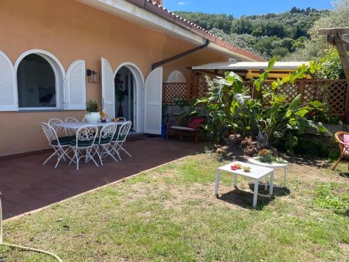 een patio van een huis met een tafel en stoelen bij Un Paradiso a Sorrento con piscina in Massa Lubrense