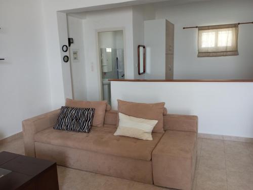 a living room with a brown couch with two pillows at Kyriaki's Studio Aigina in Souvala
