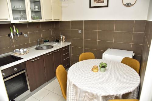 a kitchen with a table and chairs and a sink at Apartman U2 in Veliko Gradište
