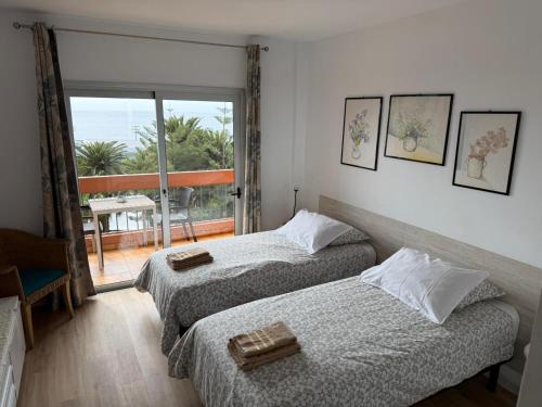 twee bedden in een kamer met uitzicht op de oceaan bij Valle Luz Apartment Ocean View in Puerto de la Cruz