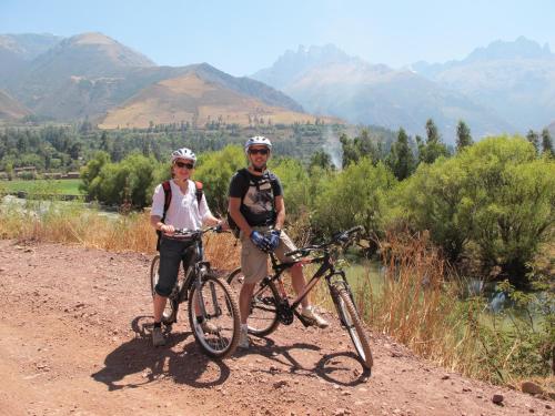 two people standing next to their bikes on a dirt road at Casa Jazmín Hospedaje Familiar Eco Amigable - Huayoccari, Sacred Valley in Huayoccare